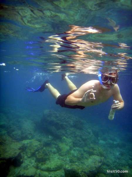 traveler snorkeling with bread in a plastic bottle to attract fish.