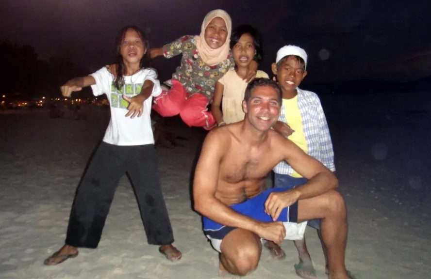 Visit50 founder Todd with four Filipino kids on the beach after sunset
